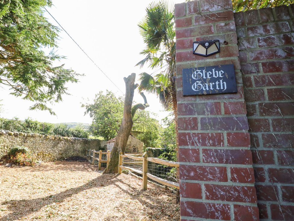 An outdoor area with a sign and tree at Glebe Garth in Chale near Niton