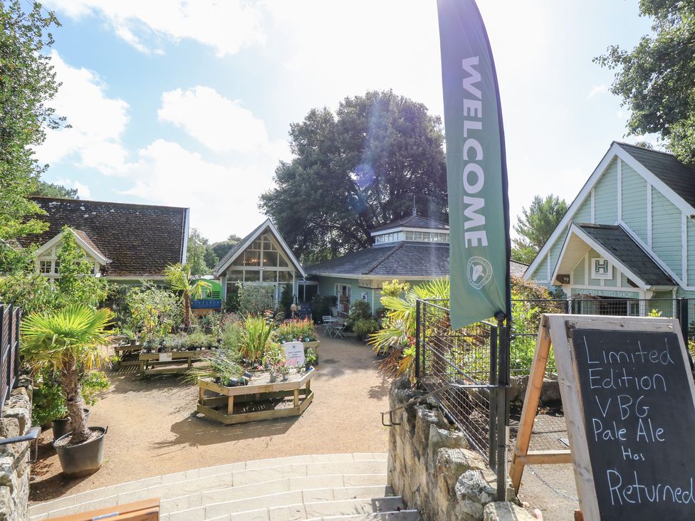 An outdoor garden area with plants and a welcoming flag at Glebe Garth in Chale near Niton