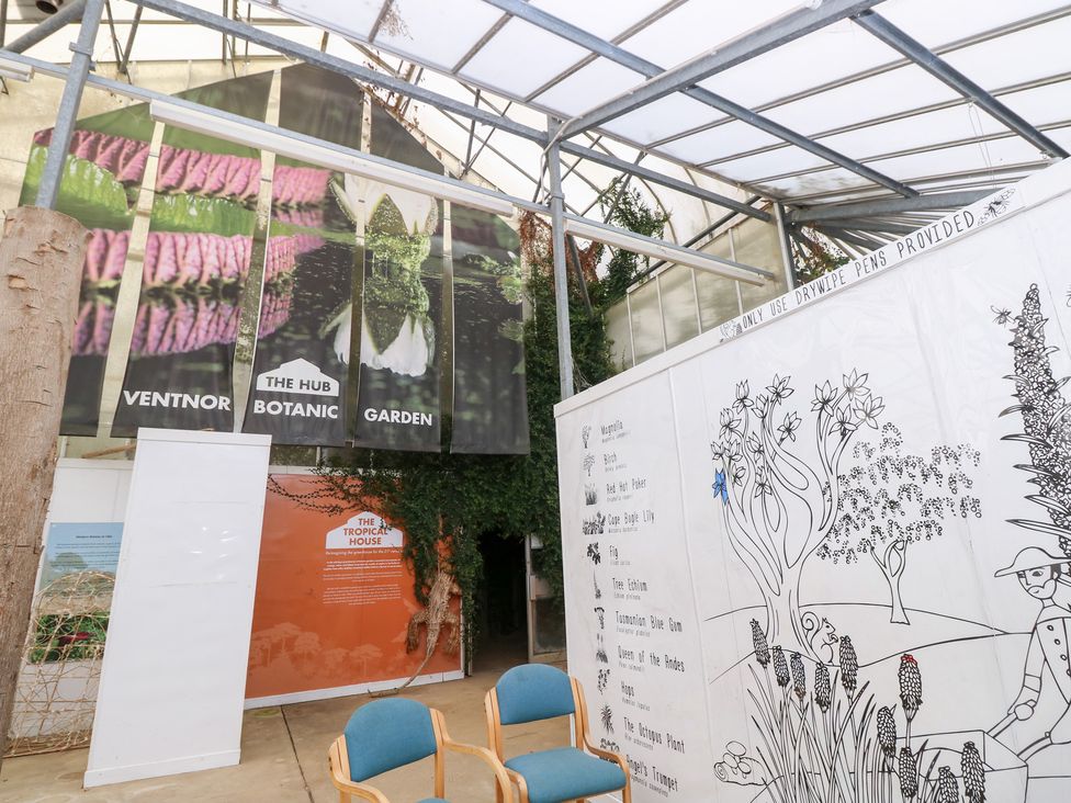 An indoor botanical garden exhibit with banners and seating at Glebe Garth in Chale near Niton
