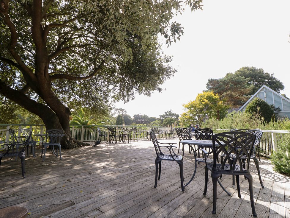 An outdoor dining area with tables and chairs at Glebe Garth in Chale near Niton