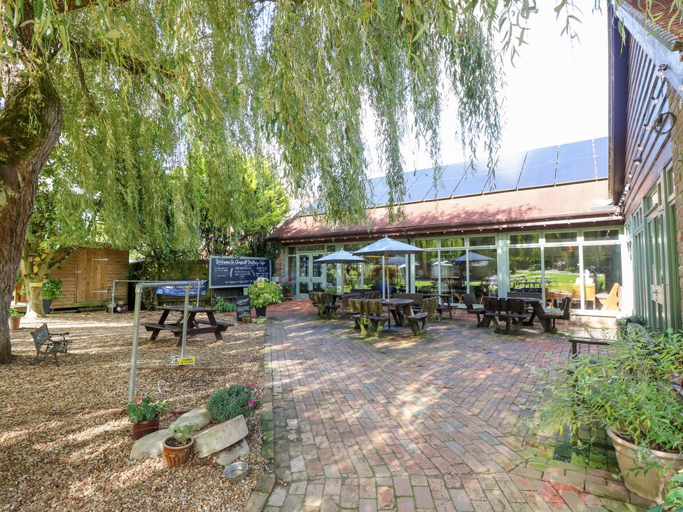 An outdoor seating area with tables and chairs at Glebe Garth in Chale near Niton