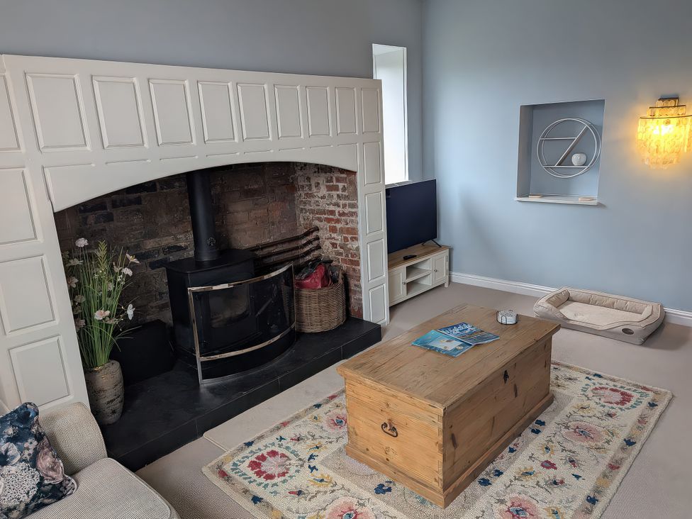 A living room with a fireplace and television at Glebe Garth Chale near Niton