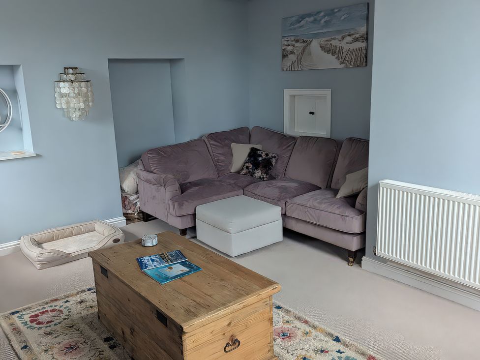 A living room with a sofa and coffee table at Glebe Garth in Chale near Niton