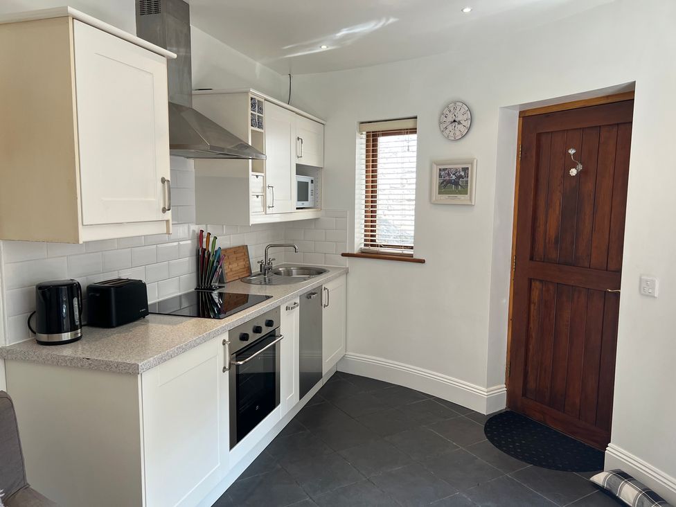 A kitchen with cabinets and appliances at Poppy's Footprint in Leyburn