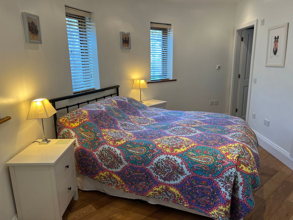 A bedroom with a bed and bedside tables at Poppy's Footprint in Leyburn