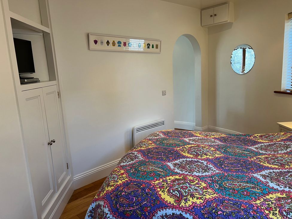 A bedroom with a bed and television at Poppy's Footprint in Leyburn