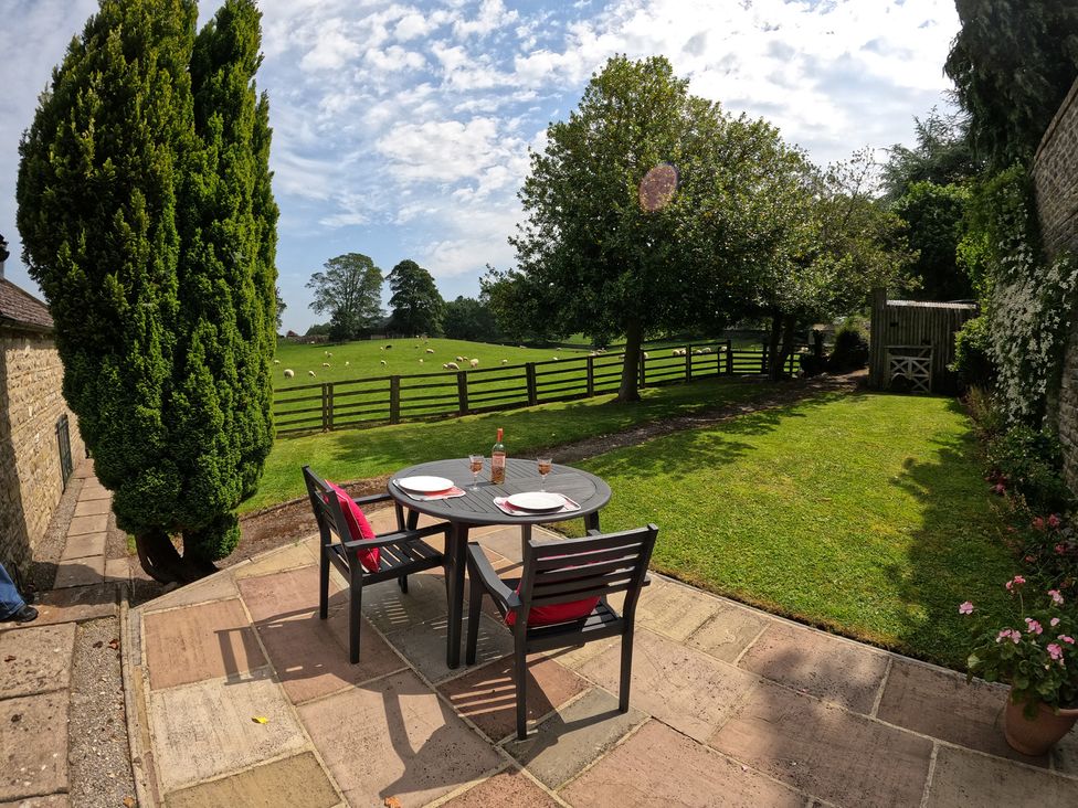 A garden with a table and chairs at Poppy's Footprint in Leyburn