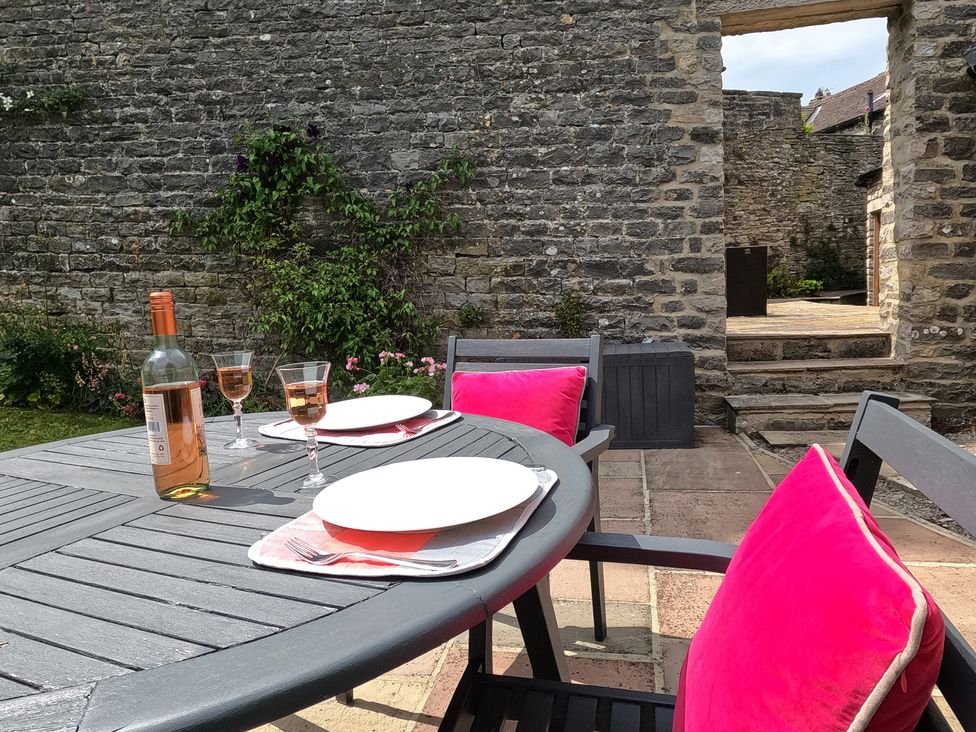 An outdoor patio with a table set for drinks at Poppy's Footprint in Leyburn