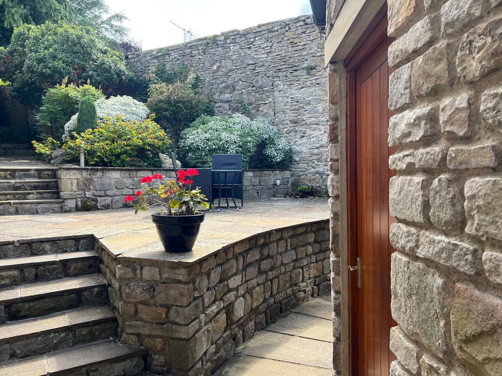 A garden with steps and a seating area at Poppy's Footprint in Leyburn