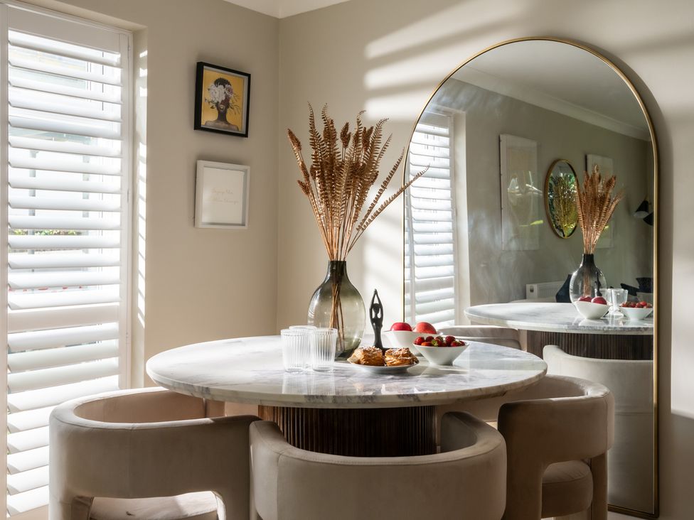 A dining area with a round table and dried flowers at Seaheaven