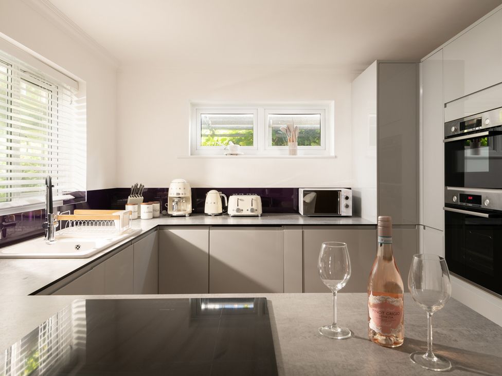 A kitchen with appliances and wine at Seaheaven