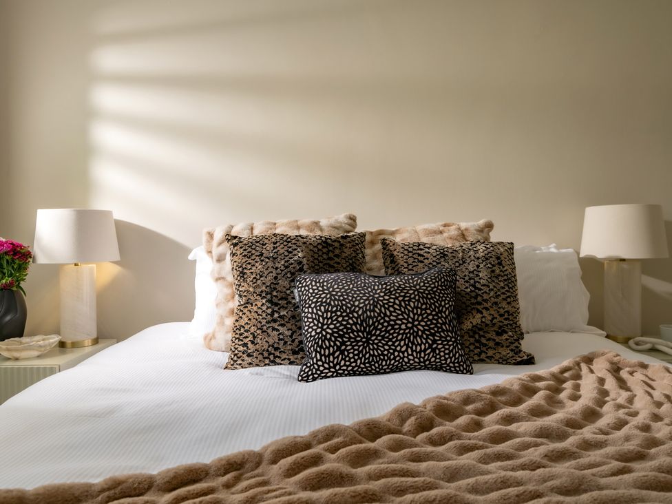 A bed with pillows and lamps in a bedroom at Seaheaven