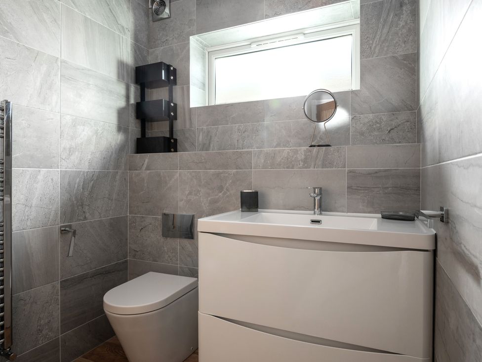 A bathroom with a sink, toilet, and mirror at Seaheaven