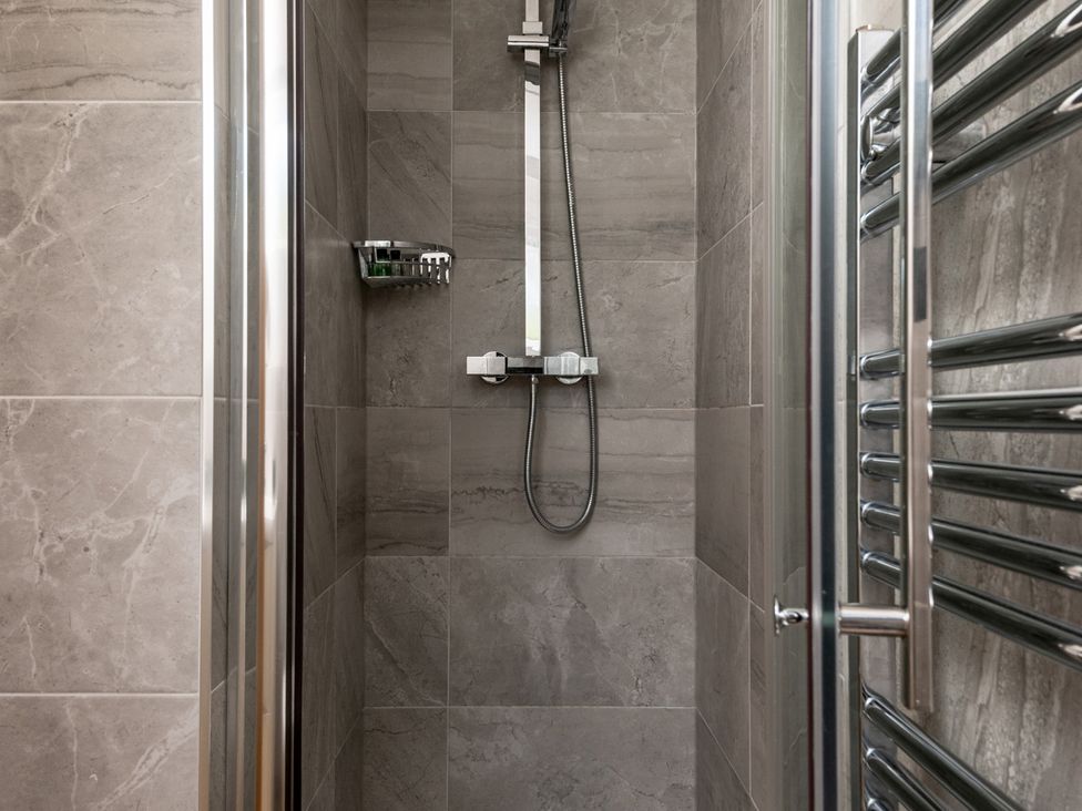 A shower setup with tiles and a towel rack at Seaheaven