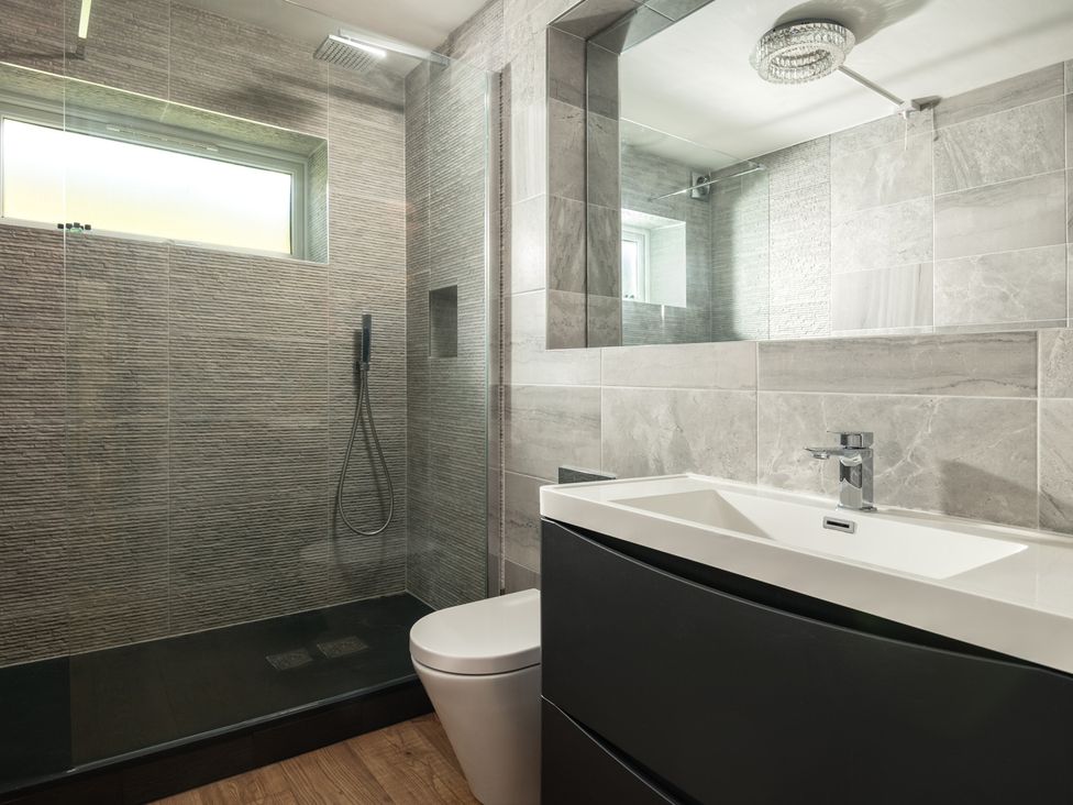 A bathroom with a shower, toilet, and sink at Seaheaven