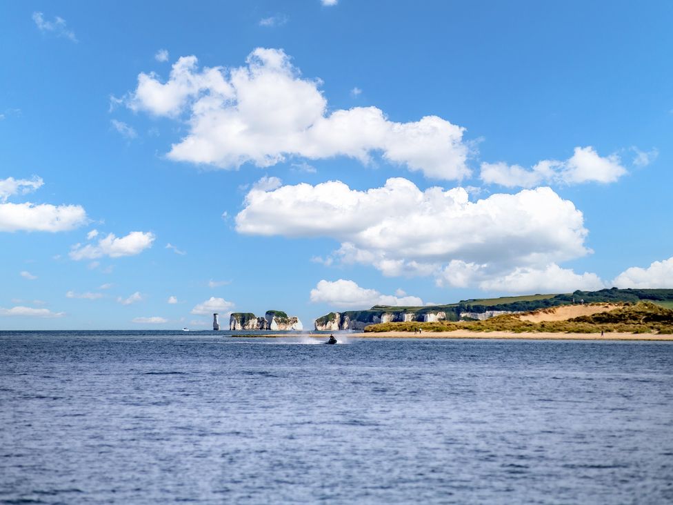 A coastal view with cliffs and a boat at Seaheaven