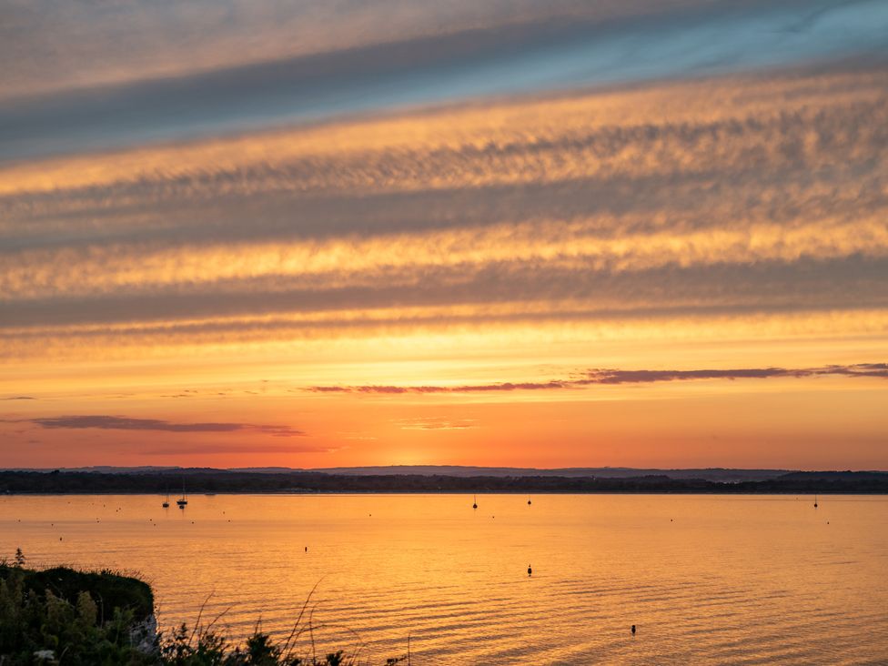 A sunset over water with boats in the area at Seaheaven