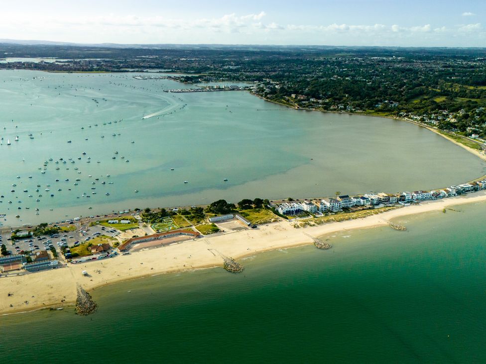 A beach area with boats in the water and nearby buildings at Seaheaven