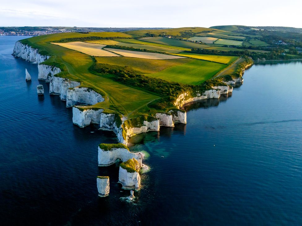 An aerial view of cliffs and fields along the coastline at Seaheaven
