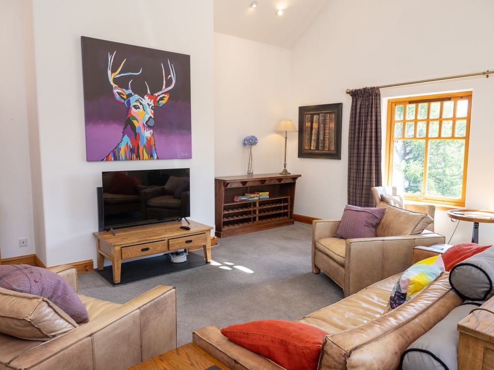 A living room with a television and art on the wall at Old Distillery Lodge