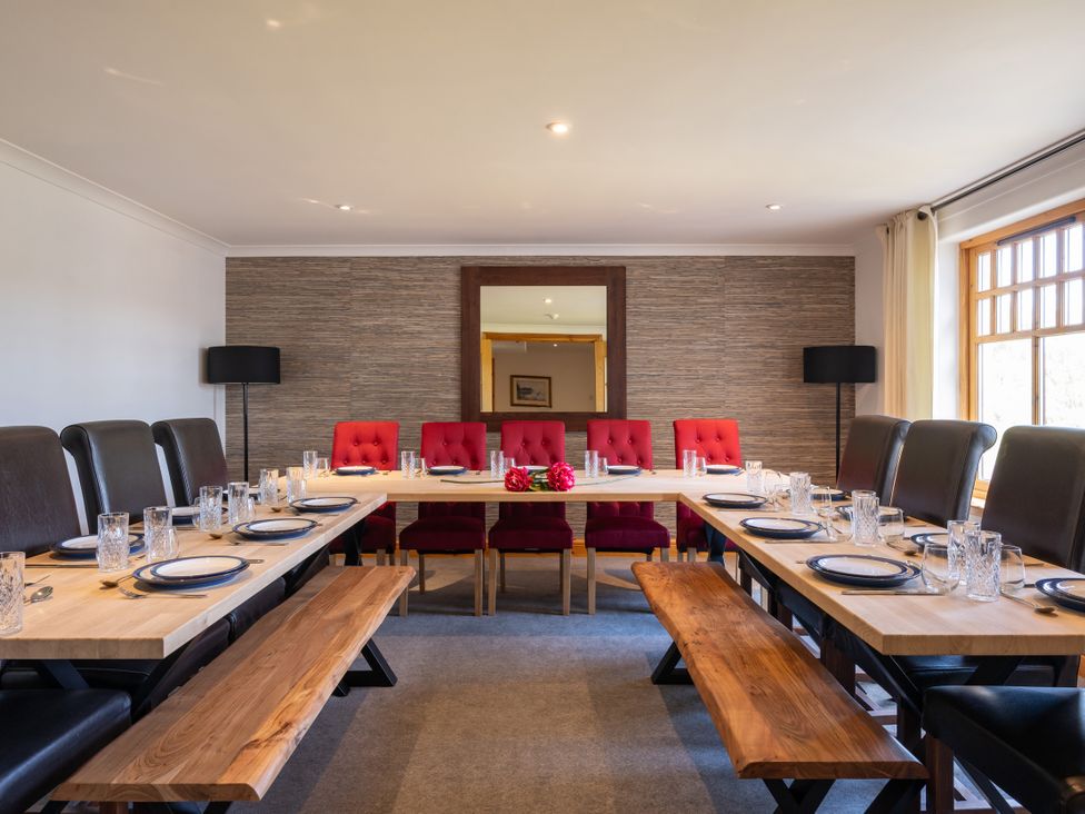 A dining room with a long table set for meals at Old Distillery Lodge