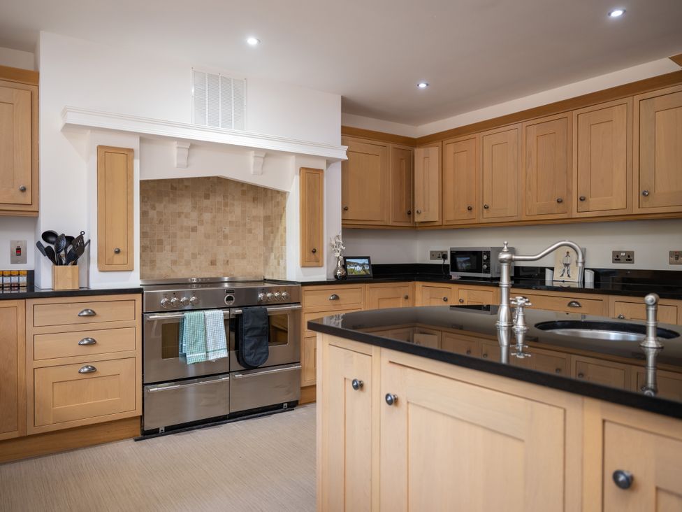 A kitchen with cabinets and a stainless steel oven at Old Distillery Lodge