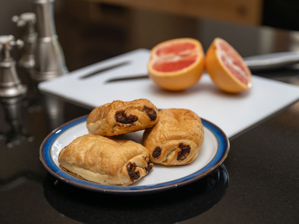 A plate with croissants and a cutting board with half a grapefruit at Old Distillery Lodge 