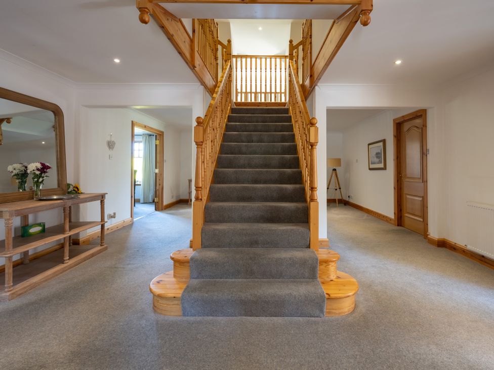 A staircase with a wooden railing in a hallway at Old Distillery Lodge