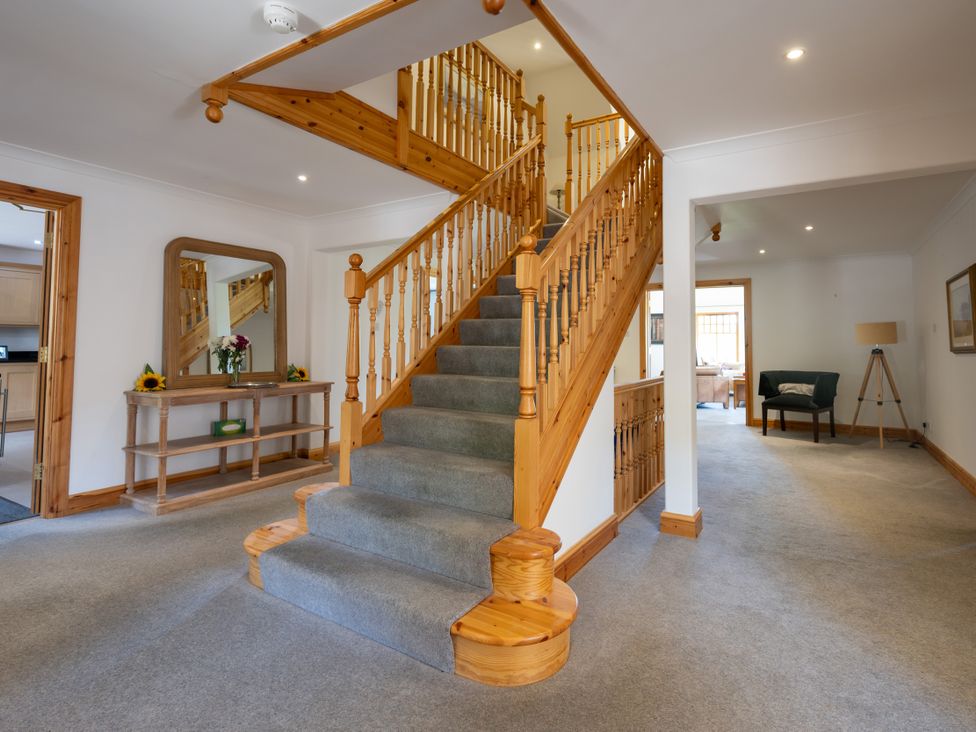 A hallway with a staircase and console table at Old Distillery Lodge
