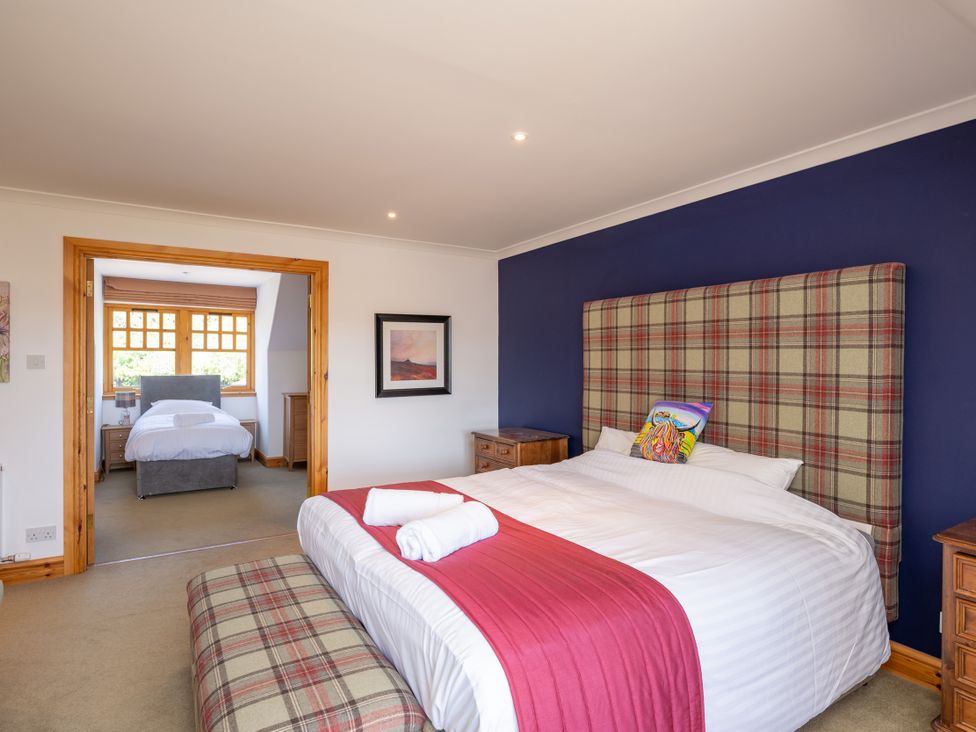 A bedroom with a large bed and adjoining room at Old Distillery Lodge
