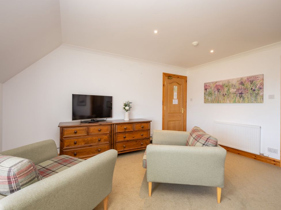 A living room with a television and chest of drawers at Old Distillery Lodge