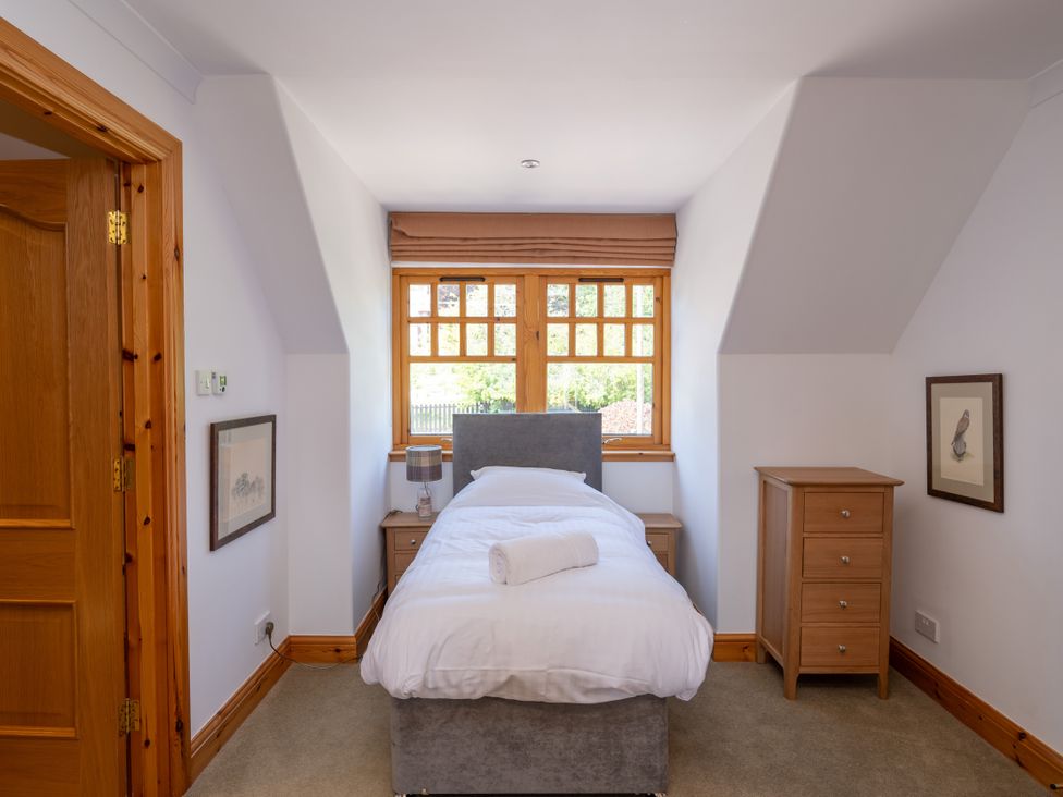 A bedroom with a single bed and a window at Old Distillery Lodge