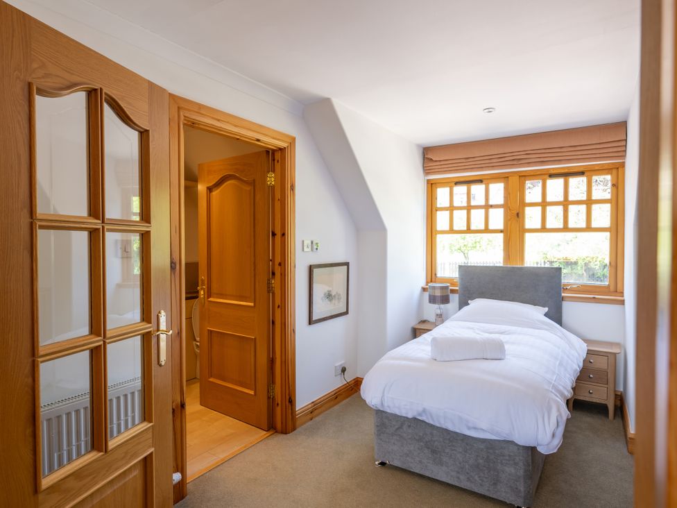 A bedroom with a single bed and bedside table at Old Distillery Lodge