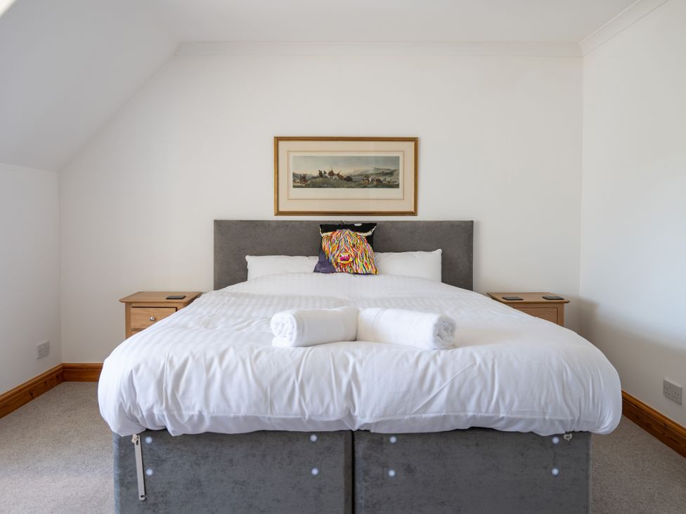 A bedroom with a bed and bedside tables at Old Distillery Lodge