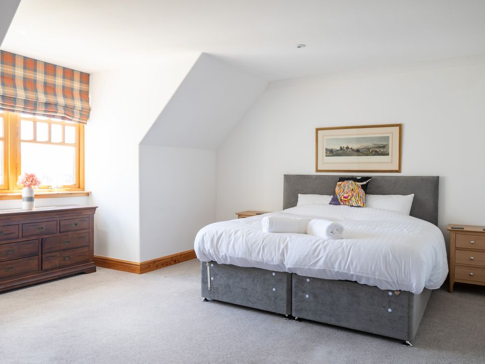 A bedroom with a bed and dresser at Old Distillery Lodge