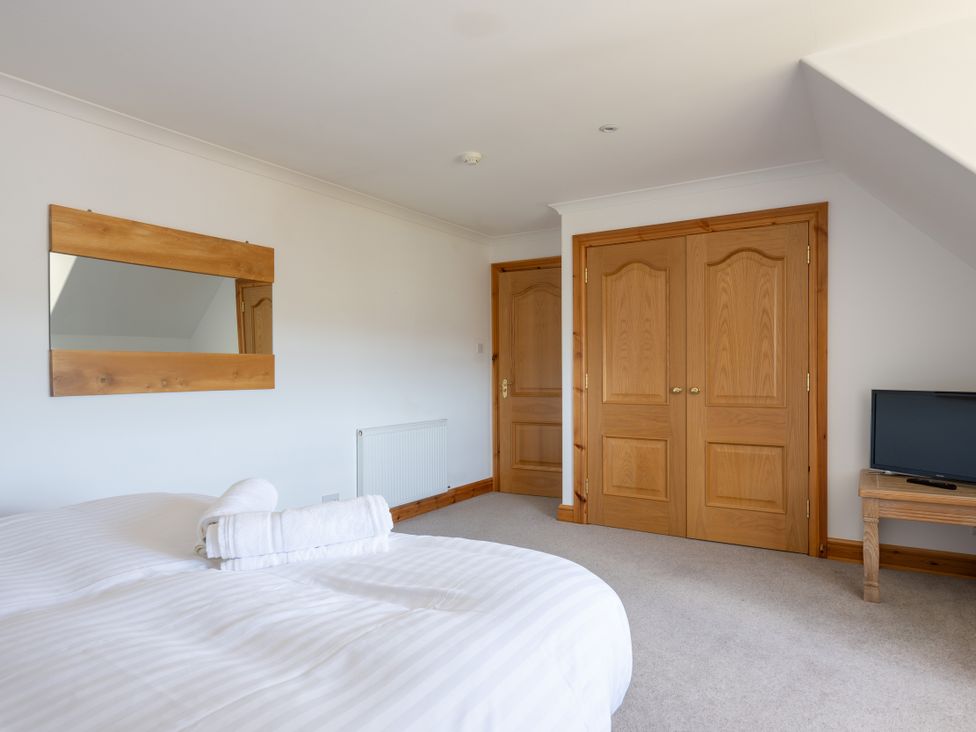 A bedroom with a bed and TV at Old Distillery Lodge