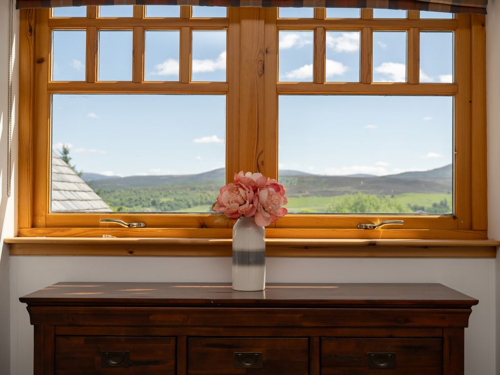 A window with a flower vase on a table at Old Distillery Lodge 
