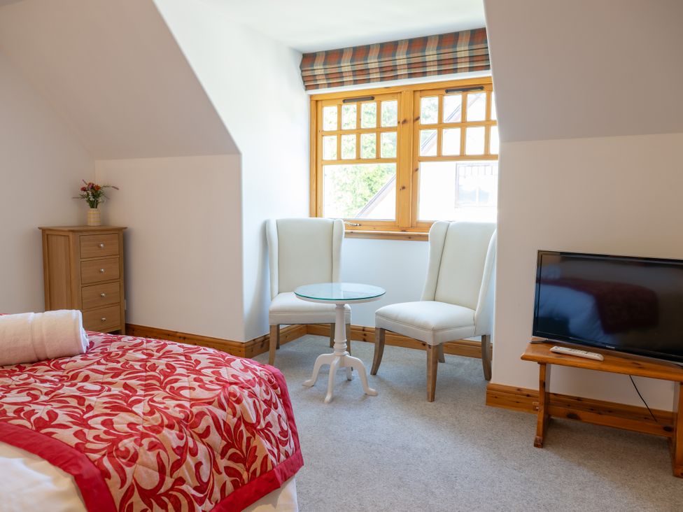 A bedroom with a bed and seating area at Old Distillery Lodge