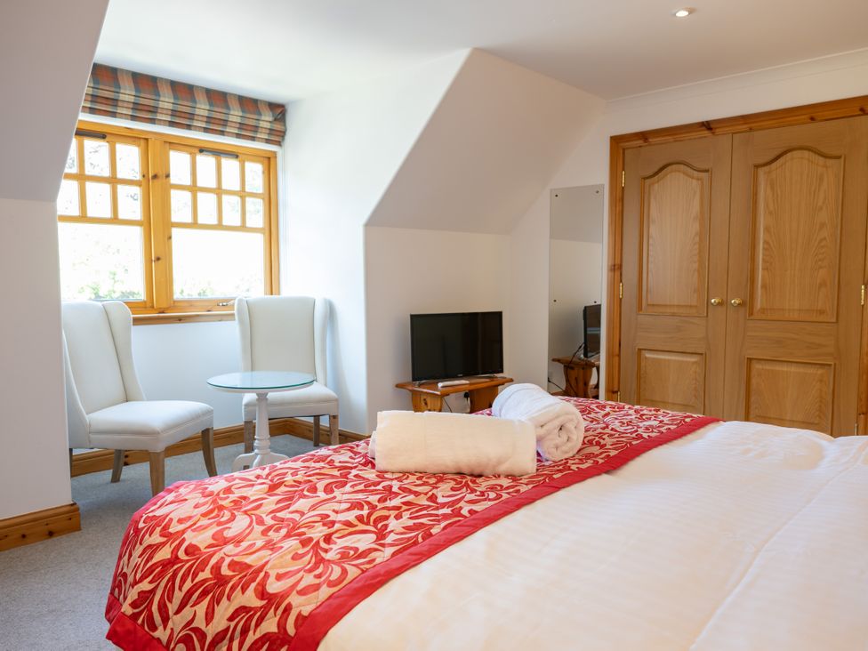 A bedroom with a bed and seating area at Old Distillery Lodge