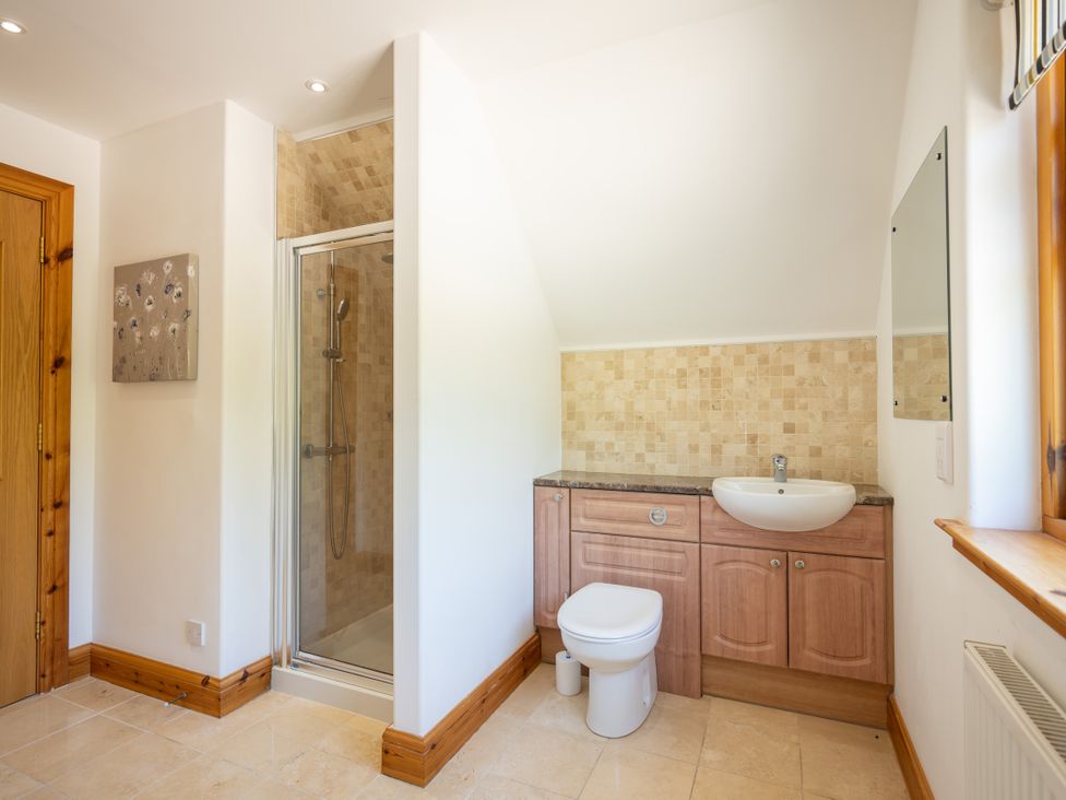 A bathroom with a shower, sink, and toilet at Old Distillery Lodge