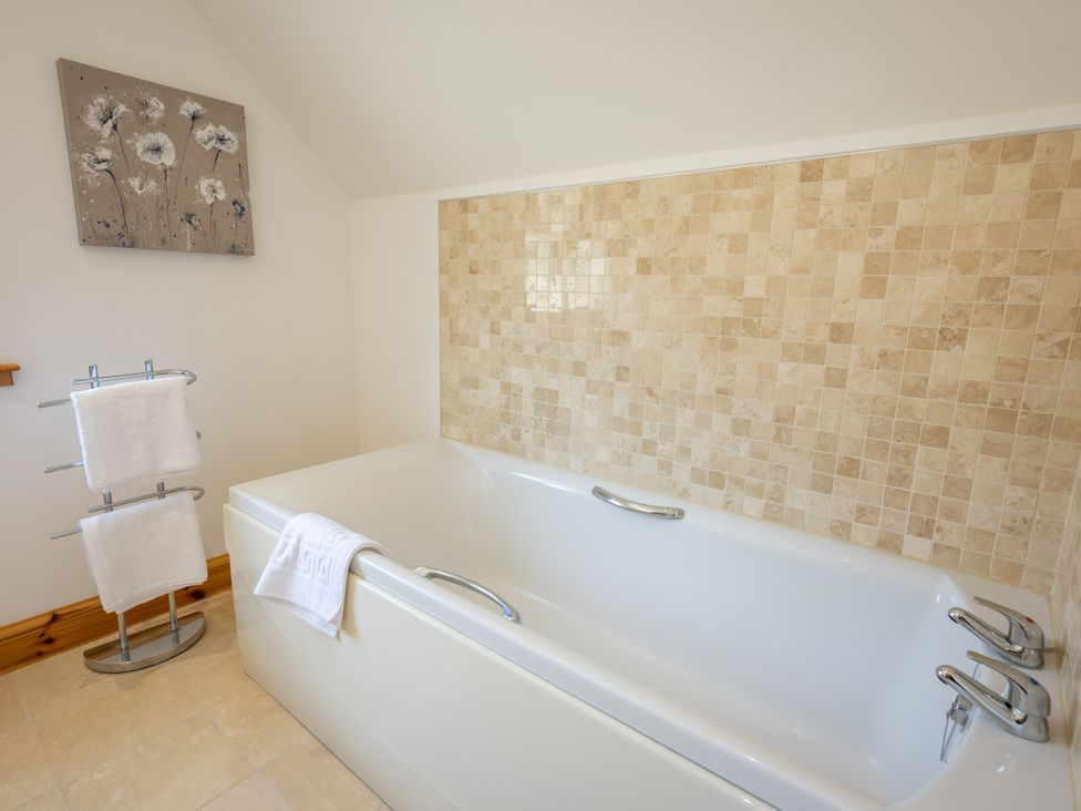 A bathroom with a bath tub and towels at Old Distillery Lodge 