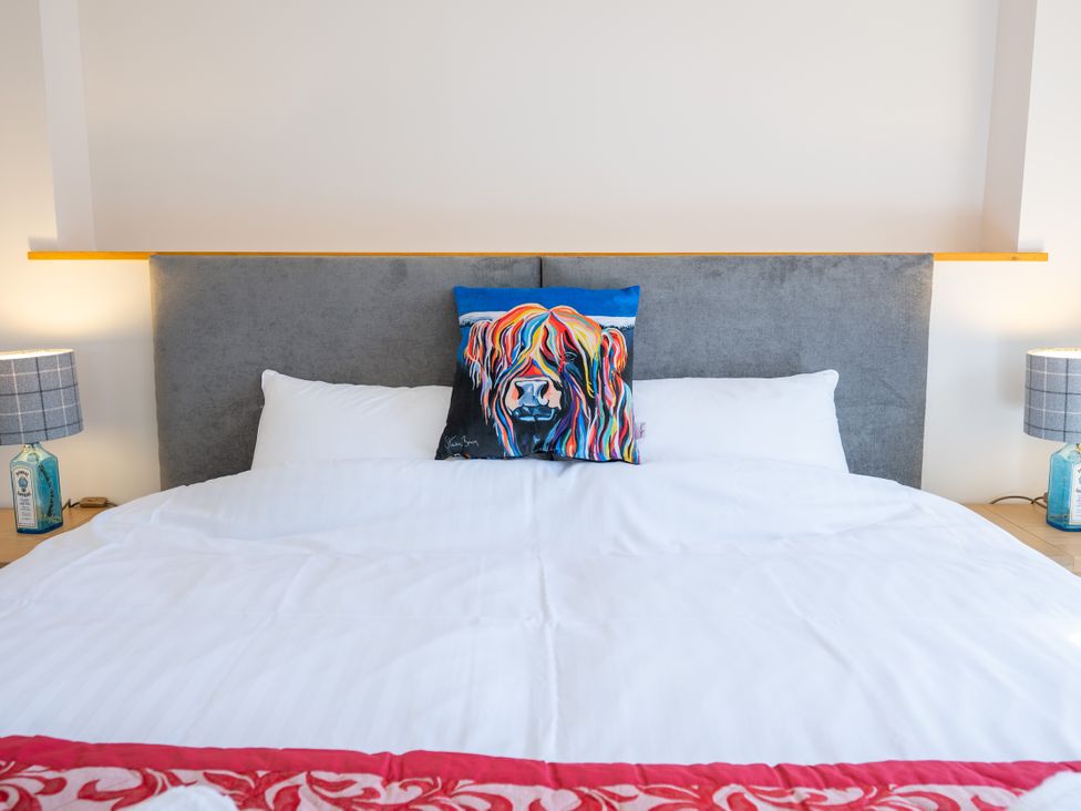 A bedroom with a bed and decorative pillows at Old Distillery Lodge 