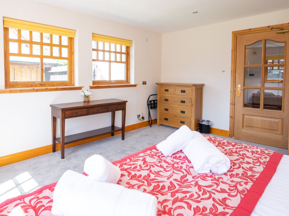 A bedroom with a bed and wooden furniture at Old Distillery Lodge 