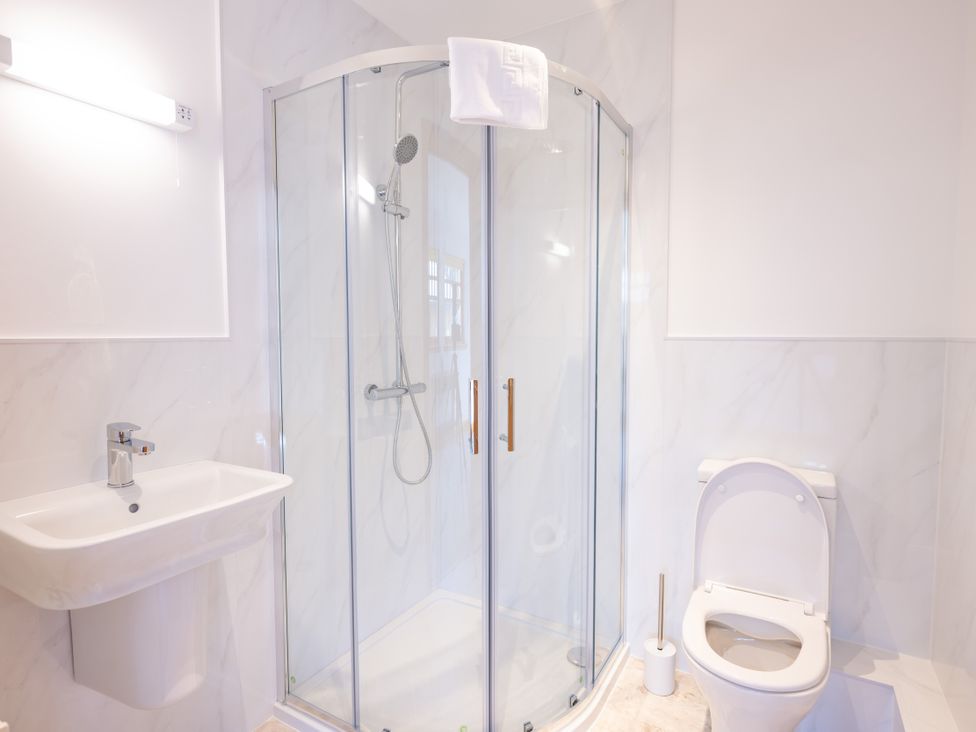 A bathroom with shower, sink, and toilet at Old Distillery Lodge