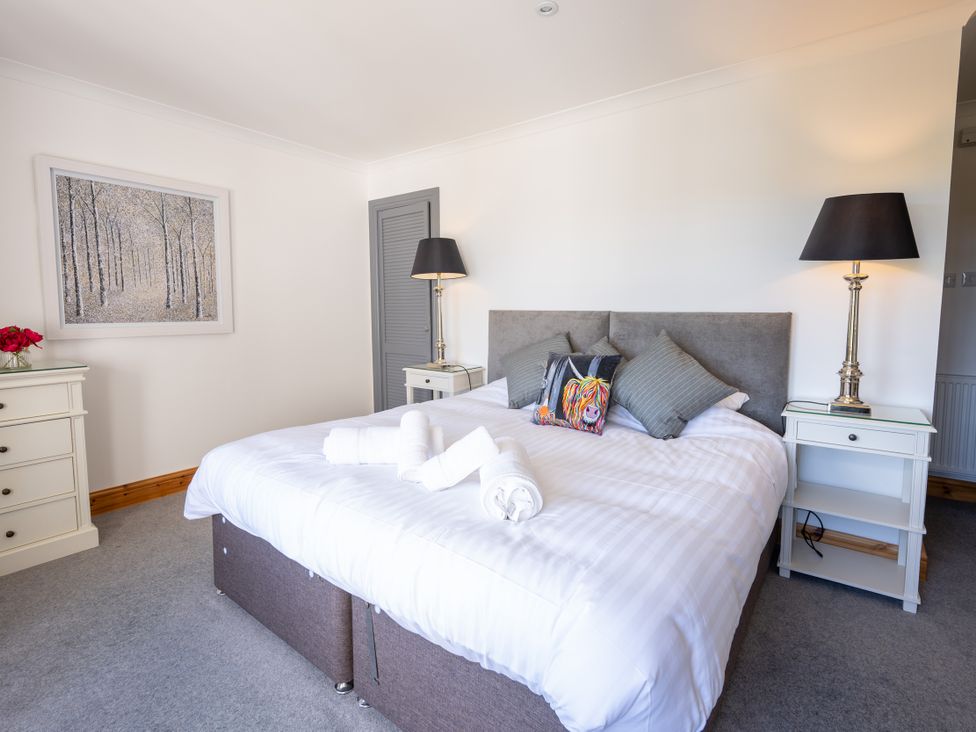 A bedroom with a bed and bedside tables at Old Distillery Lodge