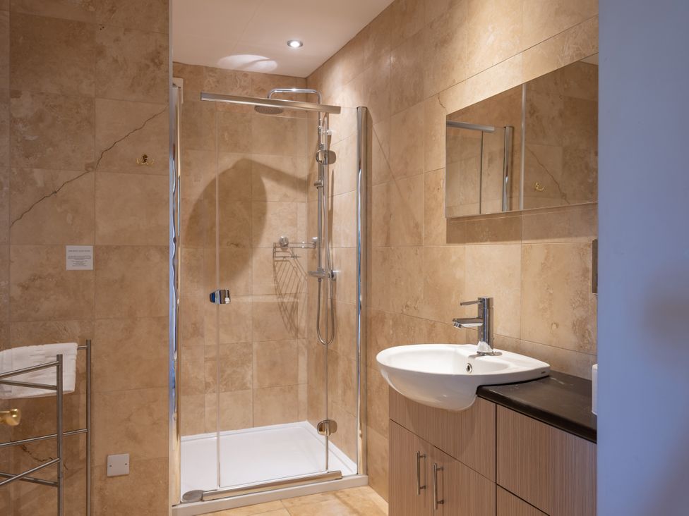 A bathroom with a shower and sink at Old Distillery Lodge