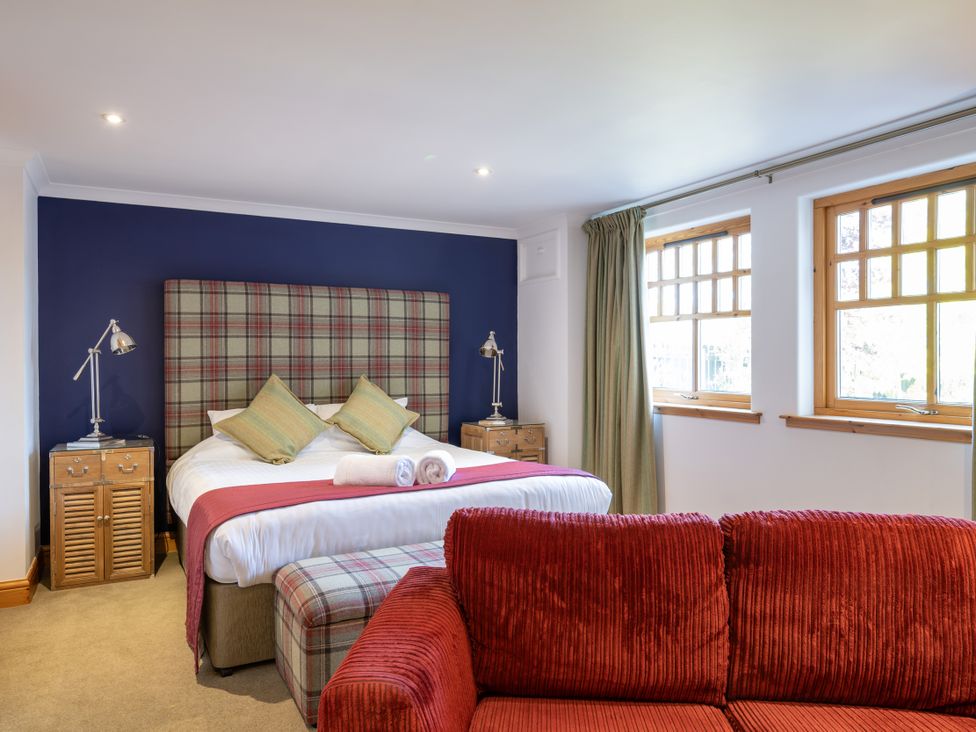 A bedroom with a bed and red couch at Old Distillery Lodge 
