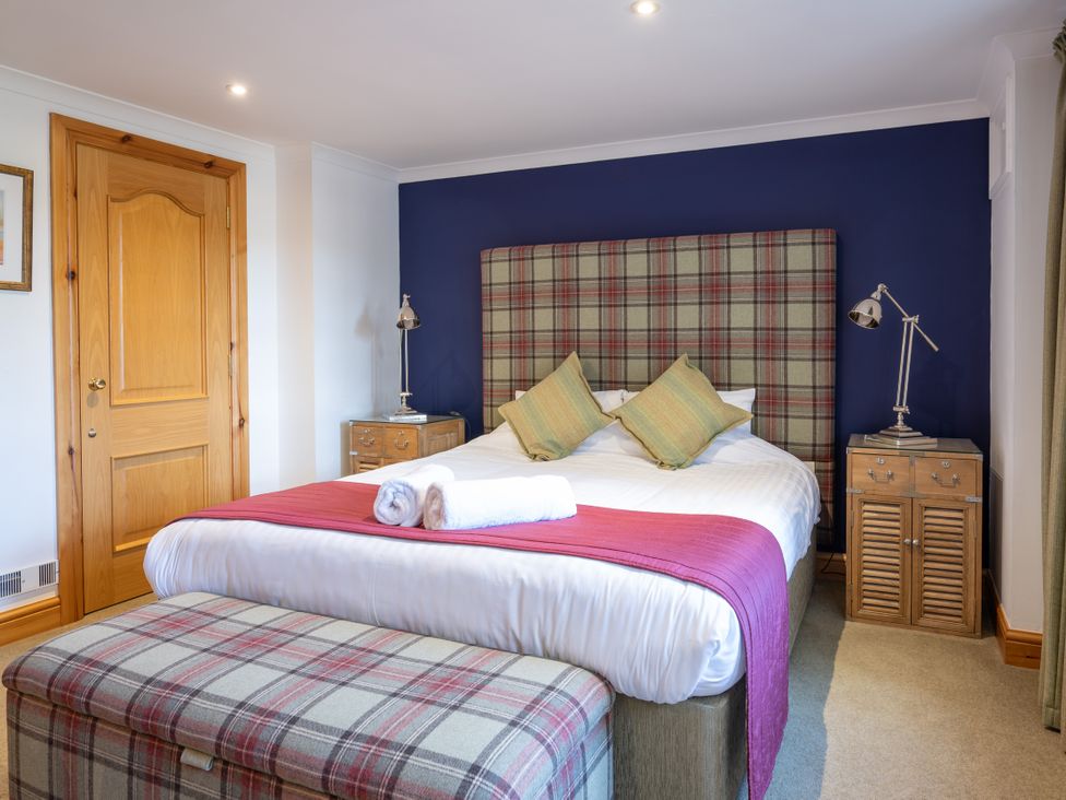 A bedroom with a bed and bedside table at Old Distillery Lodge