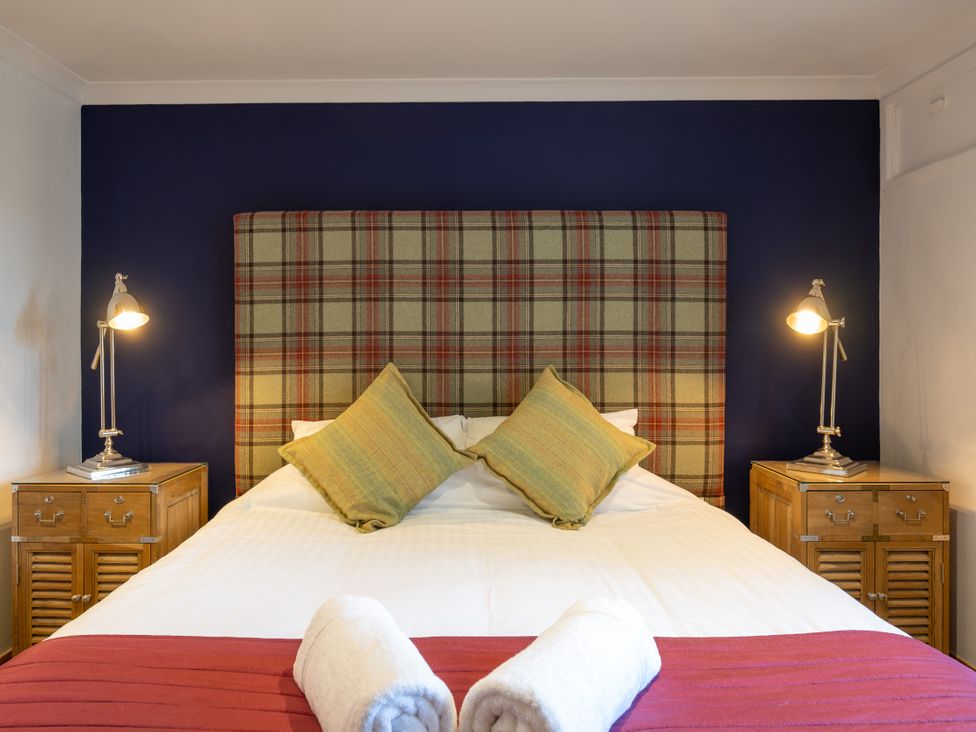 A bedroom with a bed and bedside tables at Old Distillery Lodge