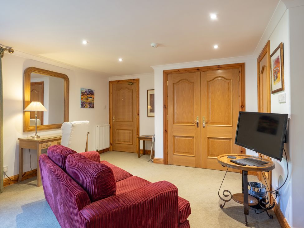 A living room with a sofa and television at Old Distillery Lodge